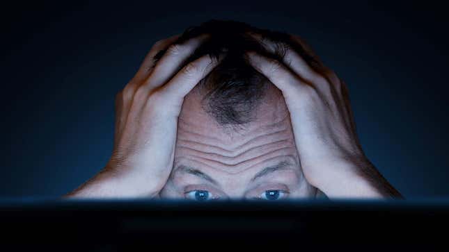 A photo shows a man stressing out behind a PC screen. 