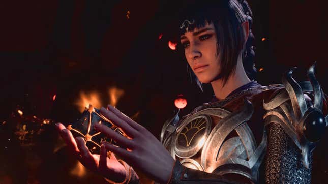 The character of Shadowheart, a cleric with dark hair in ornate metal armor, is seen in close-up looking at a polyhedral object she holds in her hands.